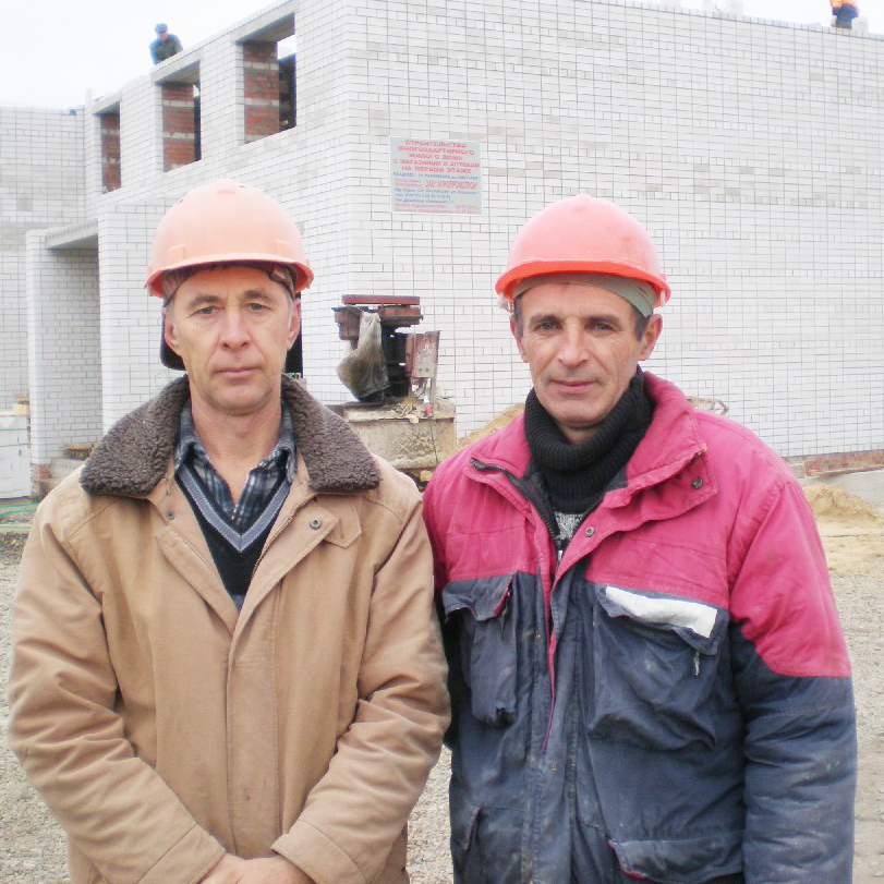 Каменьщики С.Н. Окунев и В.Т. Халёса возводят новый  12-квартирный дом