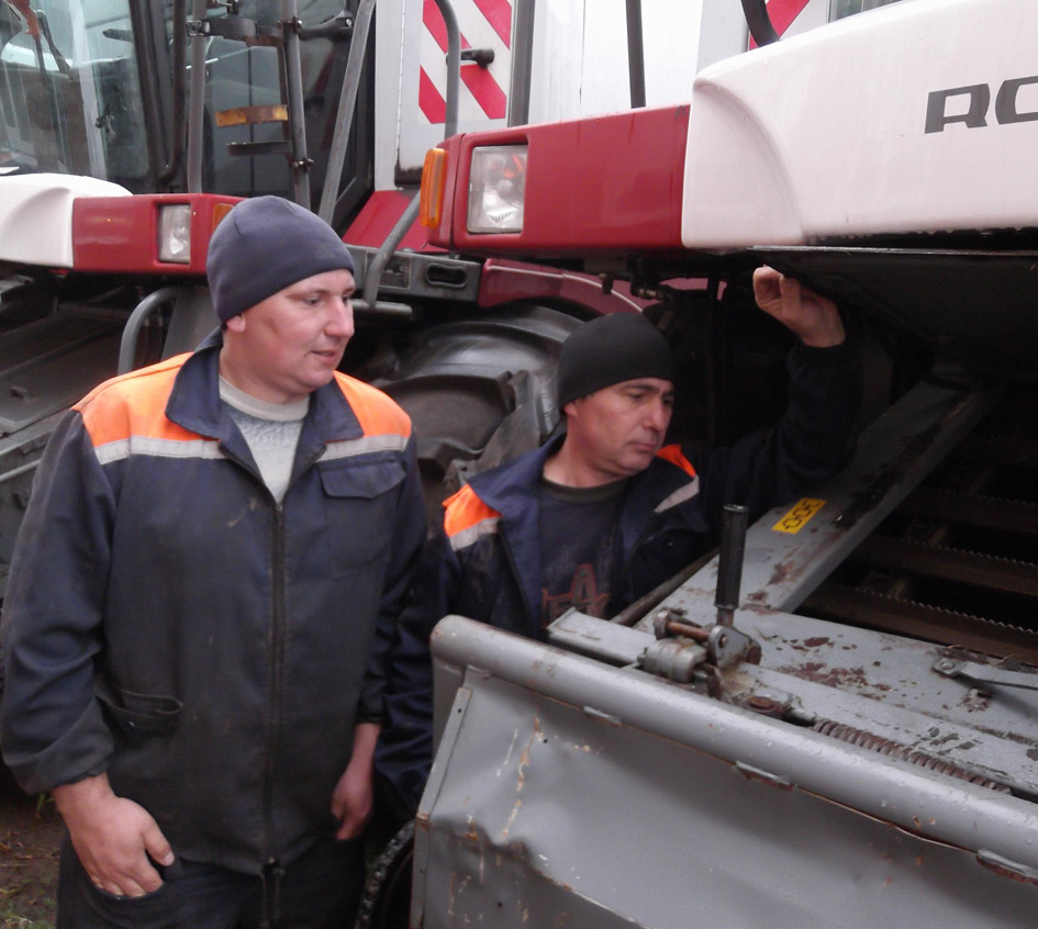 Механизатор Александр Гредчин (слева) и  Игорь Белов проводят профилактический осмотр комбайна «Акрос»